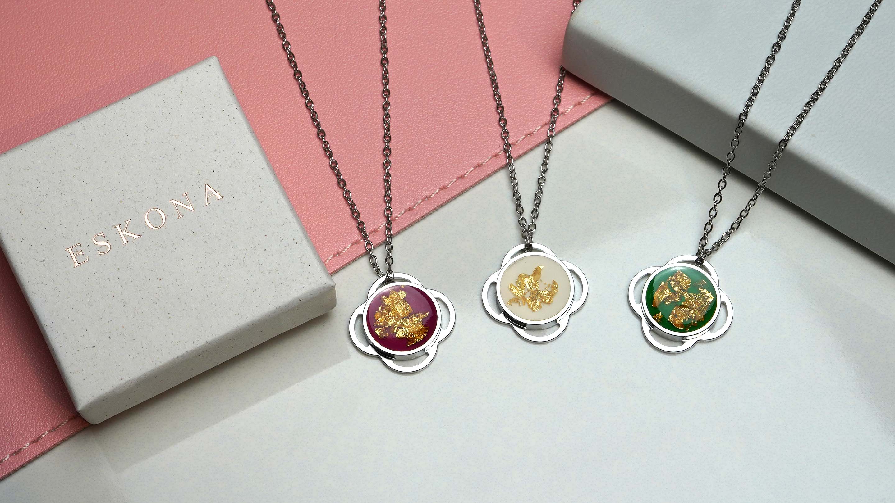 Drei bunte Edelstahl-Halsketten in Blumenform mit Blattgold-Einlage – moderner Schmuck für den Alltag